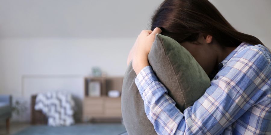 Frau hinter Kissen, Verzweiflung, Erschöpfung