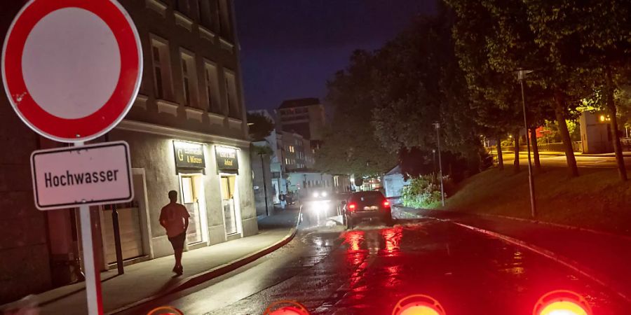 Eine Absperrschild mit der Aufschrift «Hochwasser» steht am Abend an einer Strasse nahe der Donau. Foto: Peter Kneffel/dpa