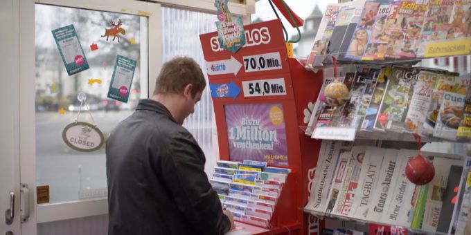 Ein Mann füllt in einem Kiosk ein Lottoschein aus. swisslos