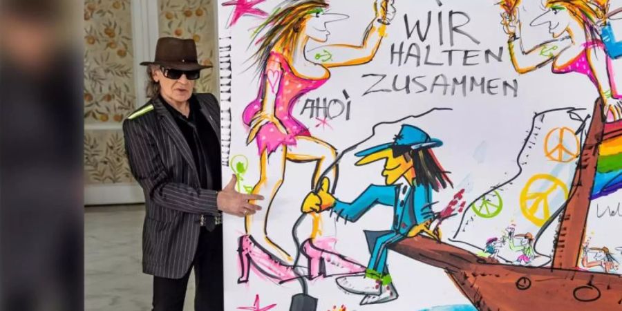 Udo Lindenberg mit seinem Bild, das zu Gunsten der Hochwasseropfer versteigert wurde. Foto: ARD/Tine Acke/dpa