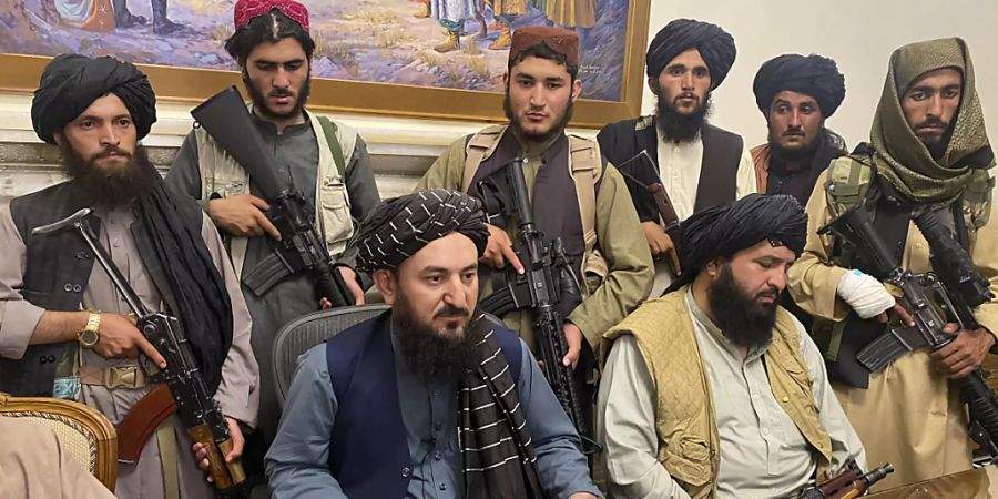 Taliban-Kämpfer sitzen in einem Raum des Präsidentenpalastes.