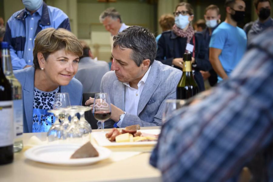 Die Bundesräte Viola Amherd und Ignazio Cassis tuscheln angeregt während dem Apéro mit der Bevölkerung im Sportzentrum des Vallée du Joux.