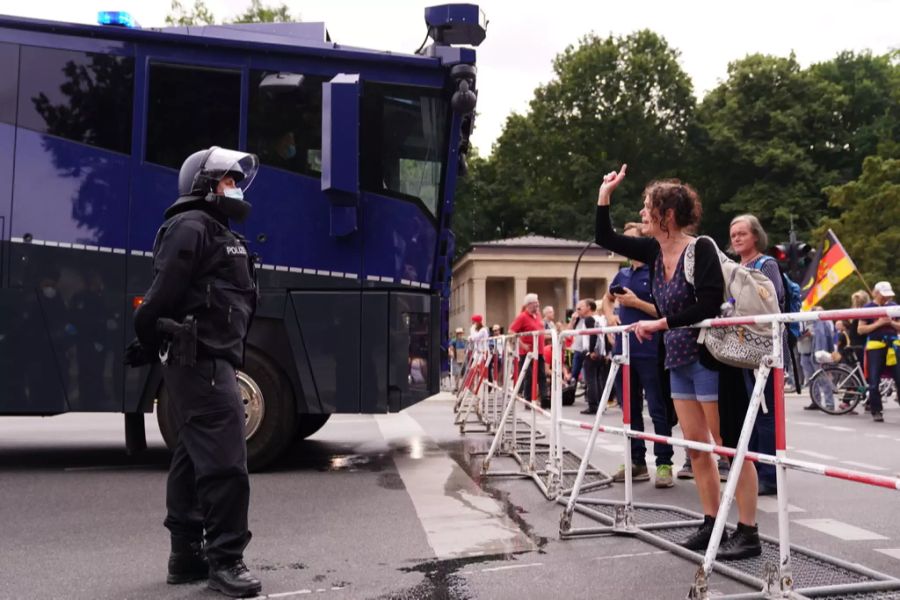 Eine Demonstrantin diskutiert mit einem Polizisten.