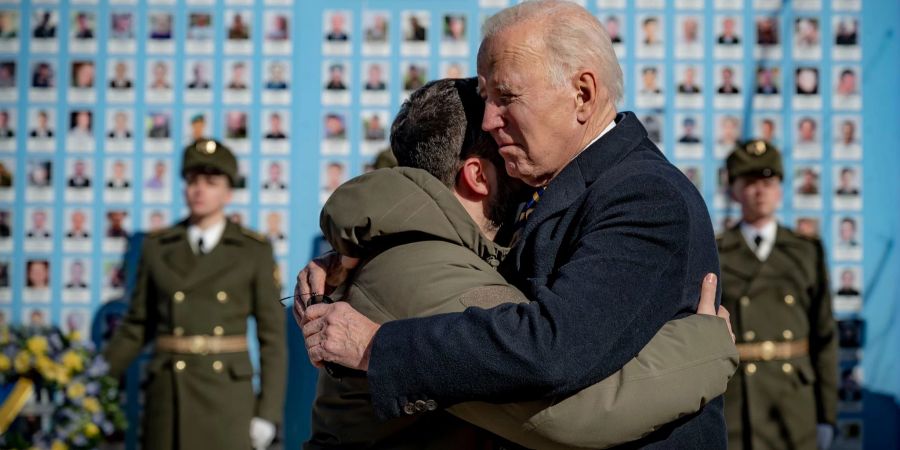 US-Präsident Joe Biden und sein ukrainischer Amtskollege Wolodymyr Selenskyj umarmen sich zum Abschied an der Gedenkmauer für die gefallenen Verteidiger der Ukraine. Uncredited/Ukrainian Presidential Press Office/AP/dpa