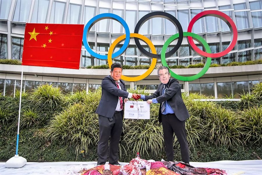 Demonstranten mit Masken des chinesischen Präsidenten Xi Jinping und IOC-Präsident Thomas Bach während einer Protestaktion am 3. Februar 2021 vor dem IOC-Hauptsitz in Lausanne.