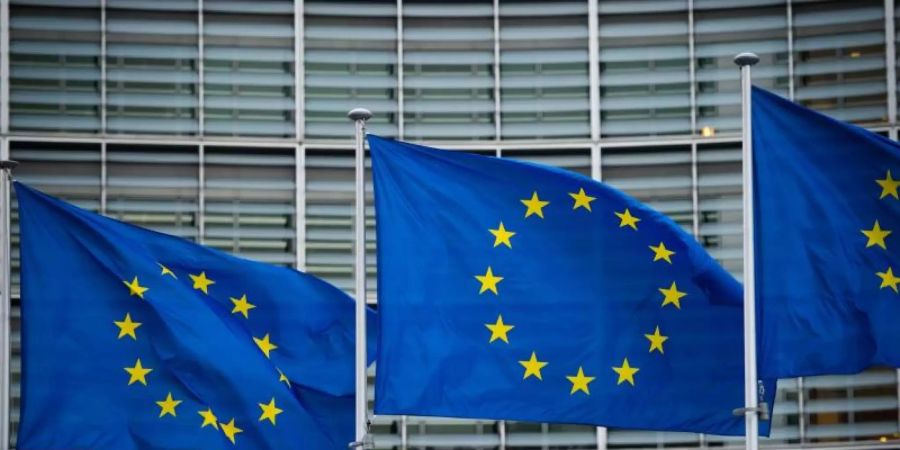 Flaggen der Europäischen Union wehen vor dem Berlaymont-Gebäude in Brüssel. Die EU-Kommission will die Haushaltsregeln für Mitgliedstaaten vereinfachen. Foto: Arne Immanuel Bänsch/dpa