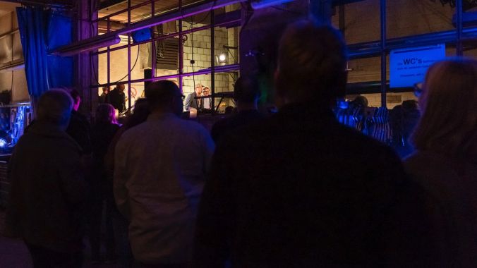 Manche Gäste ziehen es vor, das Konzert im Nebenraum (an der Bar) zu verfolgen.