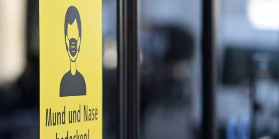 Ein Schild weist auf Maskenpflicht hin