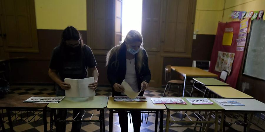 Wahlhelferinnen bereiten Stimmzettel in einem Wahllokal vor. Mit der Öffnung der Wahllokale hat in Argentinien die Parlamentswahl begonnen. Foto: Natacha Pisarenko/AP/dpa