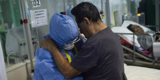 Ein medizinischer Mitarbeiter hilft einem Corona-Patienten in Peru Ein medizinischer Mitarbeiter hilft einem Corona-Patienten in Peru