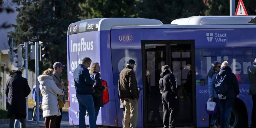 Impfwillige stehen vor einem Impfbus in Wien. Ab heute gilt die 2G-Regel für den gesamten Freizeitbereich. Foto: Herbert Neubauer/APA/dpa