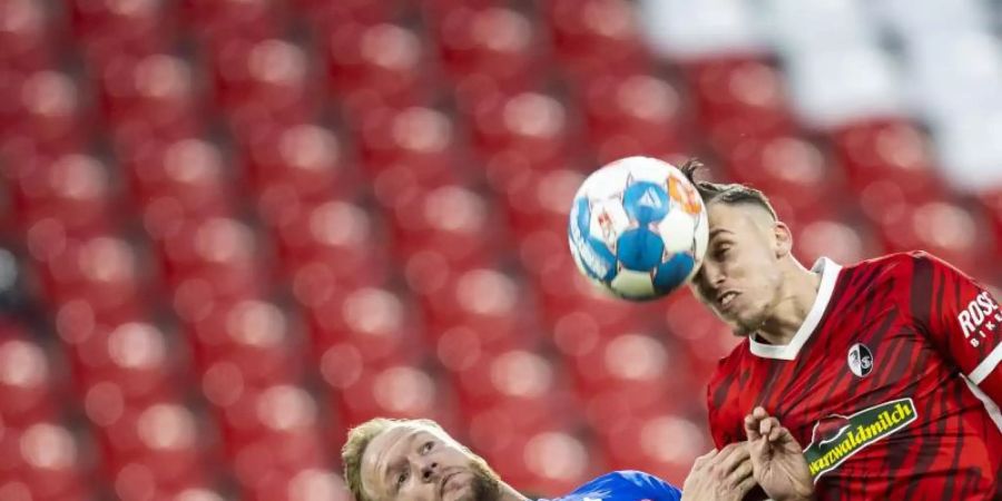 Der Freiburger Ermedin Demirovic (r) im Kopfballduell mit Kevin Vogt. Foto: Tom Weller/dpa