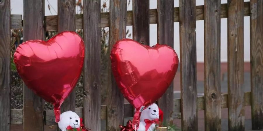 Luftballons, Plüschtiere und Kerzen liegen vor dem Haus in Glinde. Foto: Marcus Brandt/dpa