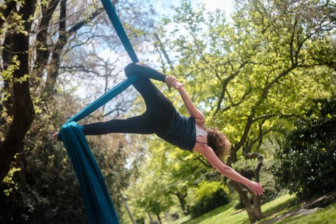 Beim Aerial Yoga werden die Übungen im und mithilfe eines Tuches ausgeführt. Aerial Yoga