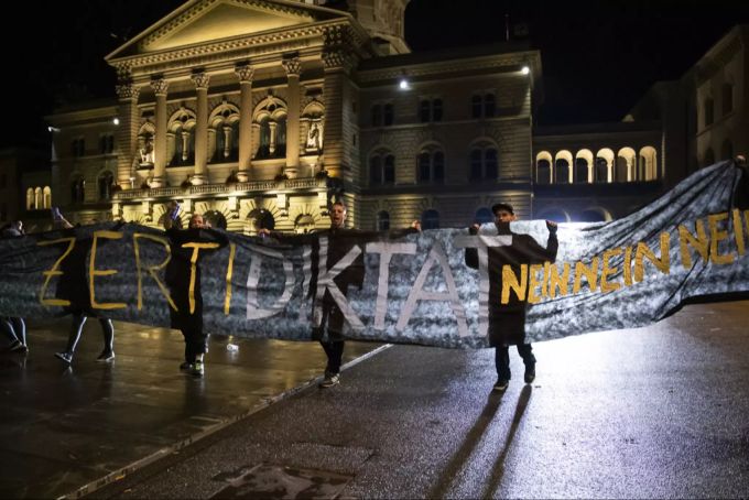 Demonstranten auf dem Bundesplatz halten ein Transparent mit der Aufschrift «Zertidiktat Nein» hoch. Covid-19-Gesetz