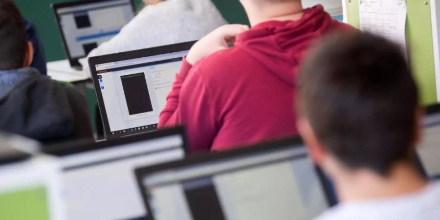 Schülerinnen und Schüler nehmen im Klassenzimmer einer 9. Klasse einer Gemeinschaftsschule am Geografieunterricht mit Hilfe von Laptops und Tablets teil. Foto: Marijan Murat/dpa