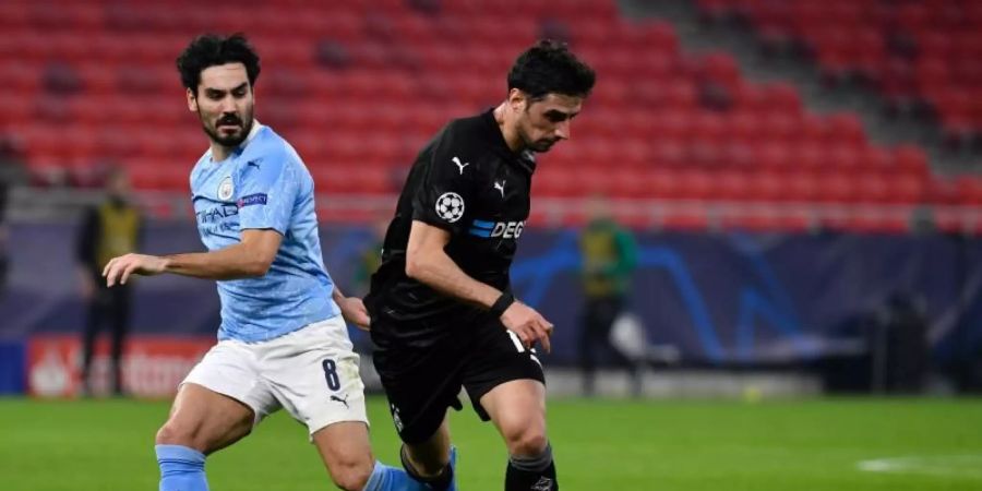 Manchester Citys Ilkay Gündogan und Gladbachs Lars Stindl (r) in Aktion. Foto: Marton Monus/dpa