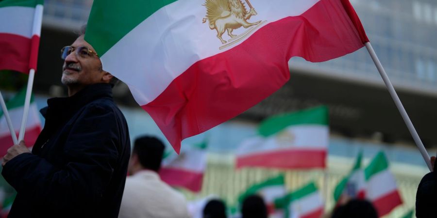 Iranische Fahnen bei einer Solidaritätskundgebung für iranische Frauen vor dem EU-Ratsgebäude in Luxemburg. Nachdem Klettermeisterin Elnas Rekabi ohne Kopftuch bei den Asienmeisterschaften teilnahm, wächst die Sorge um ihren Verbleib.