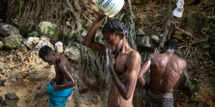 Menschen waschen sich in einer Schlucht in Port-Au-Prince.