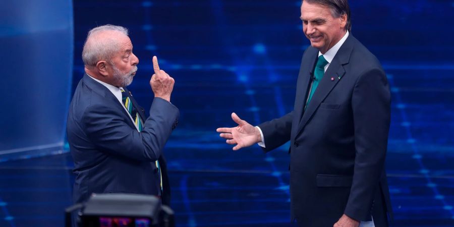 Brasiliens Präsidentschaftskandidaten Luiz Inacio Lula da Silva (l) und Jair Bolsonaro stehen sich in einem TV-Duell gegenüber.