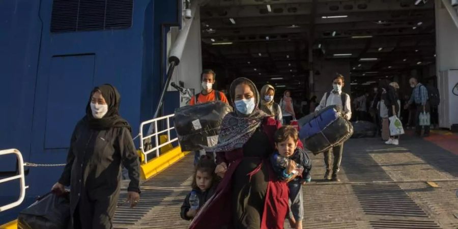 Flüchtlinge aus dem kürzlich ausgebrannten Lager Moria auf Lesbos und anderen griechischen Inseln verlassen eine Fähre im Hafen von Lavrio bei Athen. Foto: Socrates Baltagiannis/dpa