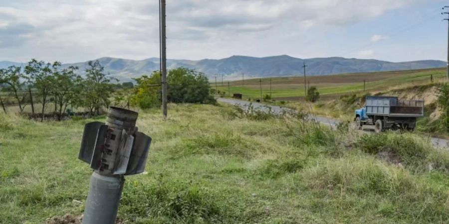 Ein Blindgänger steckt auf einer Wiese im Boden fest, nachdem das Dorf Martuni seitens der aserbaidschanischen Armee beschossen wurde. Foto: Celestino Arce Lavin/ZUMA Wire/dpa