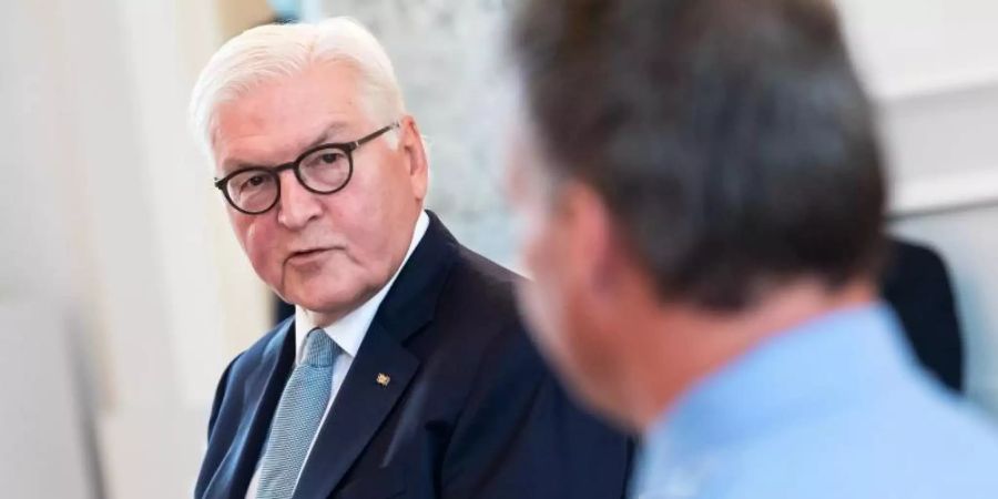 Bundespräsident Steinmeier im Gespräch mit am Reichstagsgebäude eingesetzten Polizisten. Foto: Bernd von Jutrczenka/dpa Pool/dpa