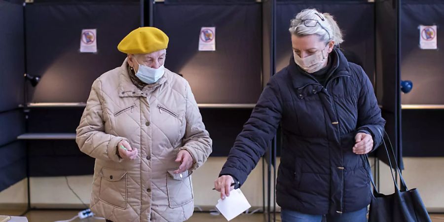 Zwei Frauen bei ihrer Stimmabgabe in einem Wahllokal in der litauischen Hauptstadt Vilnius. Foto: Mindaugas Kulbis/AP/dpa