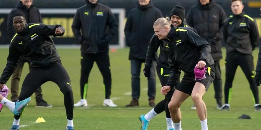 Trainer Marco Rose (hinten,M) verfolgt das BVB-Abschlusstraining, an dem auch der verletzte Erling Haaland (vorn,r) teilnimmt. Foto: Bernd Thissen/dpa