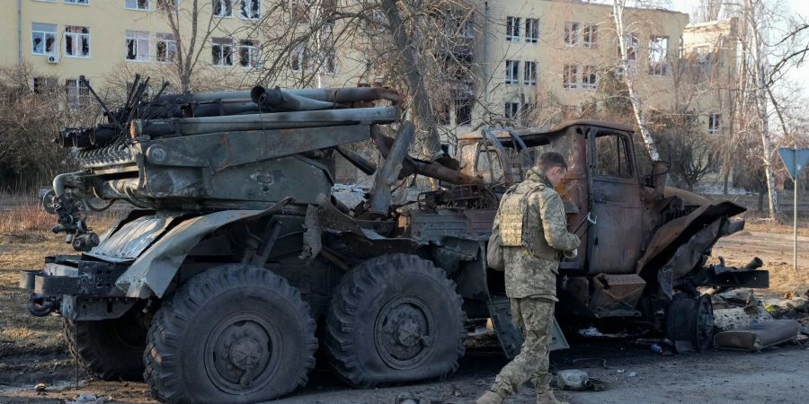 Ein ukrainischer Soldat geht in Charkiw an einem zerstörten russischen Artilleriesystem vorbei.