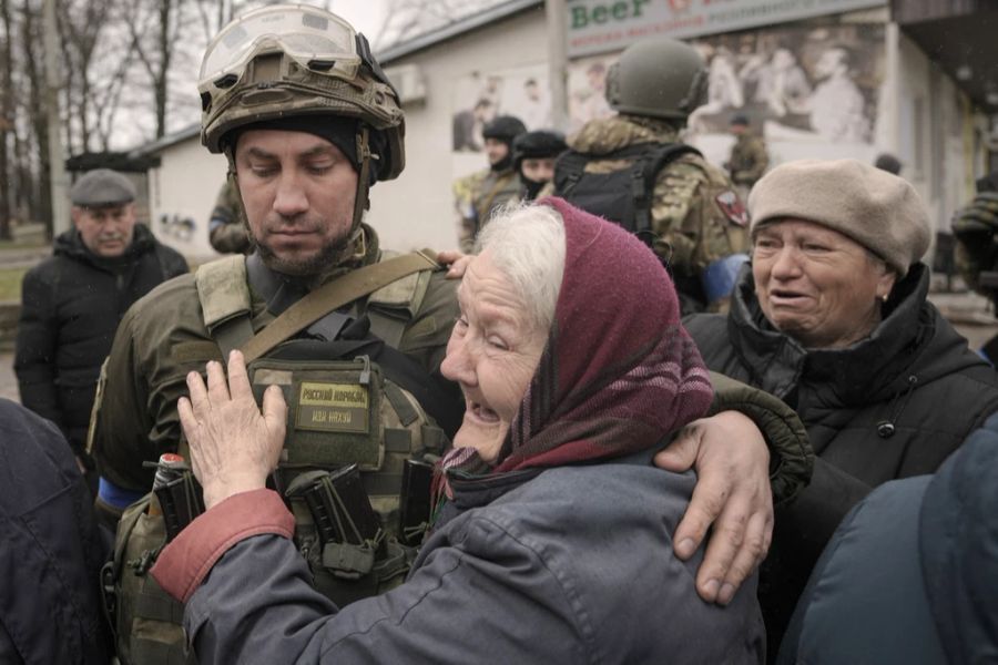 Überlebende in der Stadt Butscha begrüssen ukrainische Soldaten.