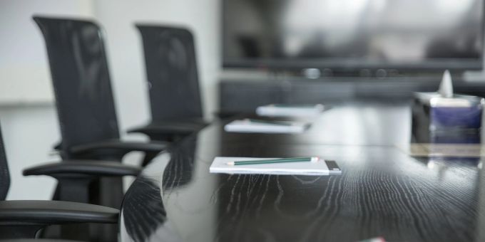 Ein neues Ratsmitglied wird bei den Sitzungen künftig dabei sein. Konferenzraum Tisch Stühle Stift Block