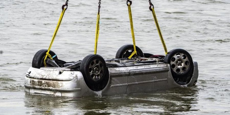Der Pkw wird in Wesel aus dem Wasser gezogen. Der Wagen mit fünf Insassen war in den Rhein gestürzt, zwei Menschen überlebten. Foto: Arnulf Stoffel/dpa