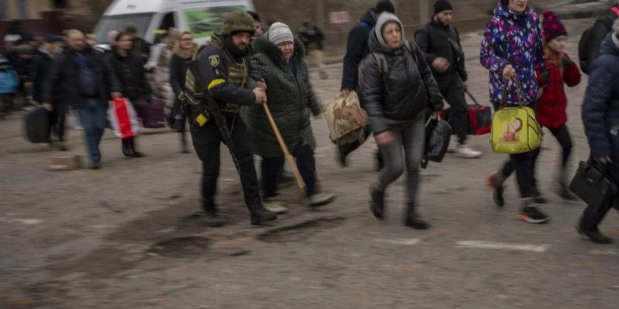 Menschen fliehen aus Irpin am Stadtrand von Kiew. Foto: Emilio Morenatti/AP/dpa