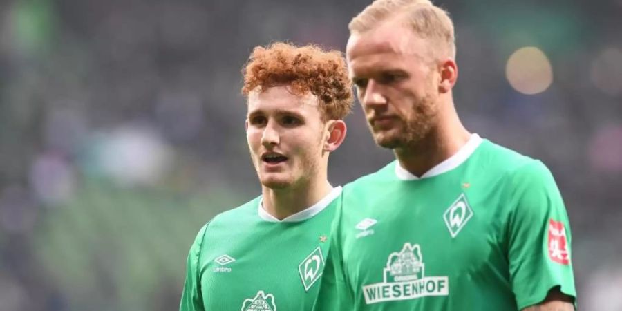 Die Bremer Kevin Vogt (r) und Josh Sargent laufen enttäuscht über den Rasen. Foto: Carmen Jaspersen/dpa