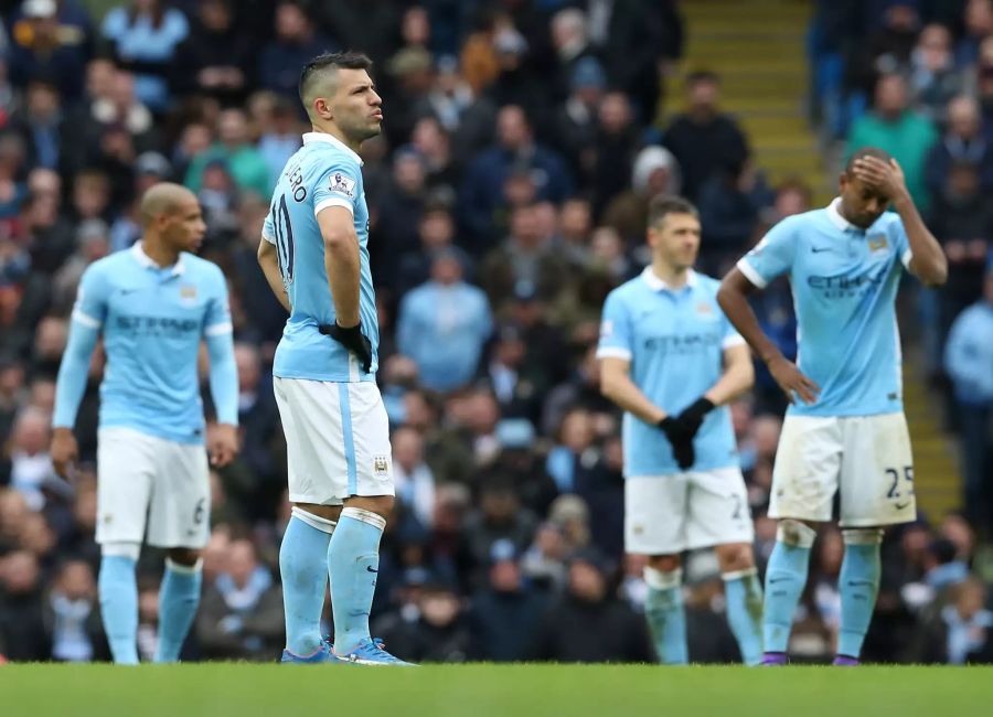 Spieler von Manchester City stehen nach einem Gegentreffer enttäuscht auf dem Platz.