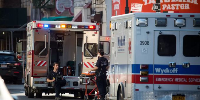 Medizinisches Personal wartet neben Krankenwagen vor einem Krankenhaus in New York auf Anweisungen. Coronavirus - USA