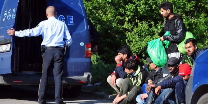 Ein Polizist und Migranten an einem Strassenrand in Nordmazedonien. (Symbolbild) Nordmazedonien Migranten