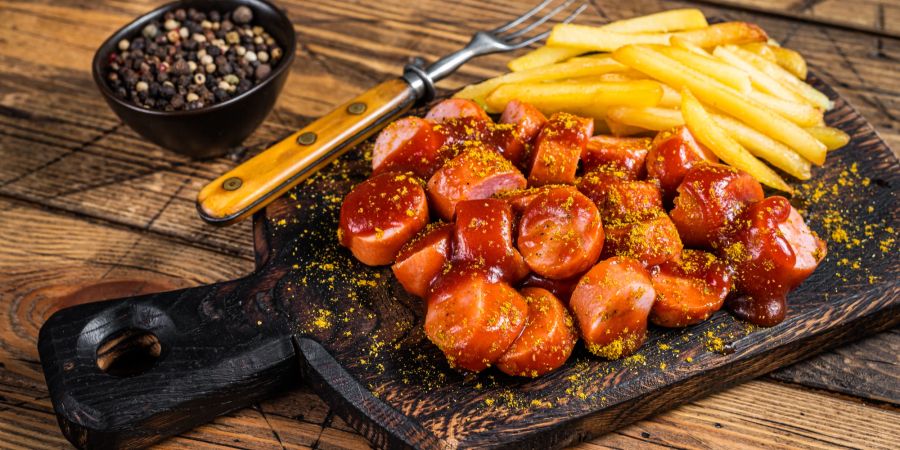 Kleingeschnittene Currywurst auf Tablett.