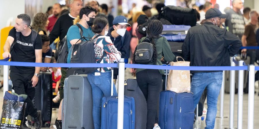 Passagiere warten auf dem Flughafen in Frankfurt am Main auf ihren Check-In.