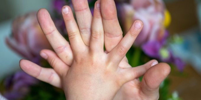 Eine Mutter hält die Hand ihrer Tochter: Kinder geben laut einer Befragung ihren Eltern am meisten Kraft in schwierigen Zeiten. kind