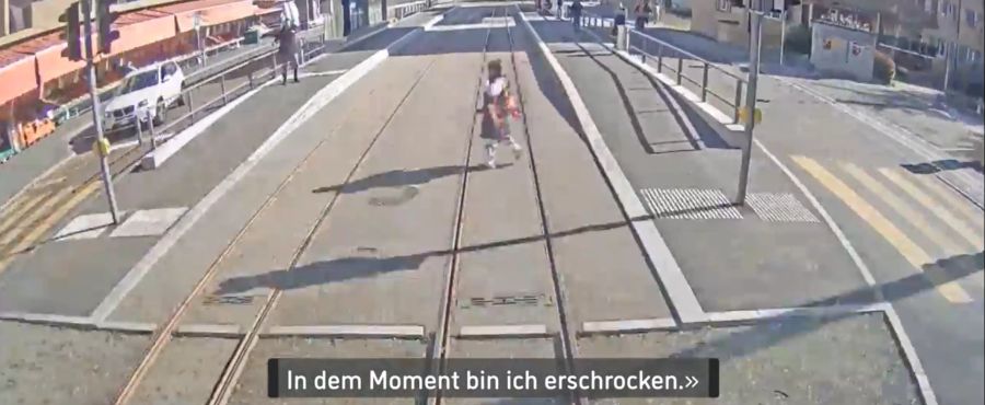 Diese Frau überquert die Gleise, ohne zu merken, dass eine Bahn heranbraust. Beinahe wäre sie dabei unter die Räder gekommen.