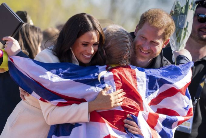 Prinz Harry und Meghan Markle umarmen eine Medaillen-Gewinnerin der Invictus Games. Prinz Harry Meghan Markle