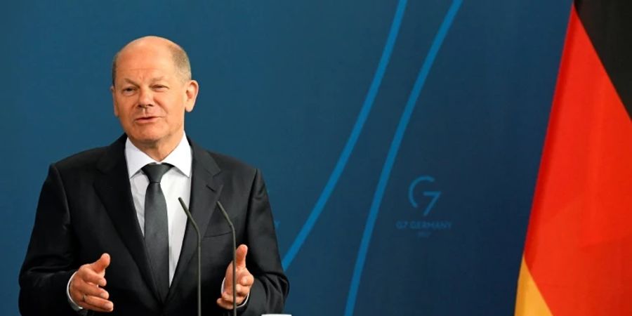 Bundeskanzler Scholz vor Wand mit G7-Logo