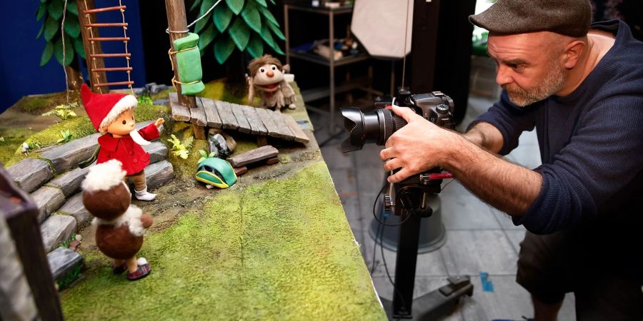 Björn Ullrich, Kamera, steht vor der Filmkulisse mit den Figuren Pittiplatsch und Sandmann im Studio in für die Produktion neuer Sandmann-Folgen. Die Filme werden in Stop-Motion-Technik produziert.