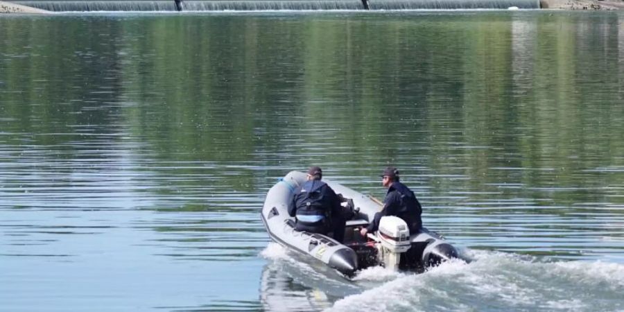 Einsatzkräfte fahren nach dem Schlauchbootunglück den Rhein ab. Foto: Benedikt Spether