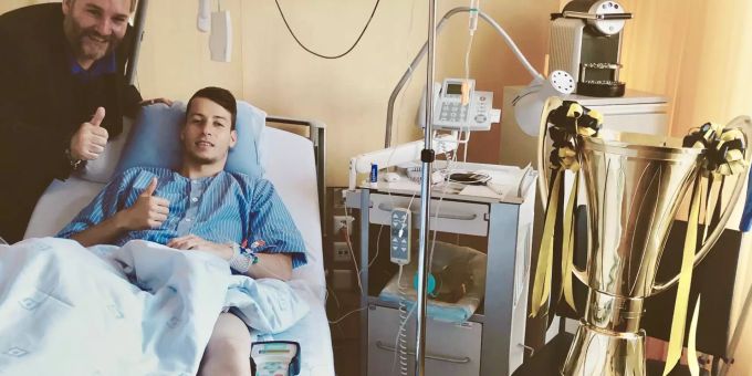YB Mittelfeldspieler Sandro Lauper nach seiner OP im Spital mit Meisterpokal und seinem Berater. YB Lauper Spital
