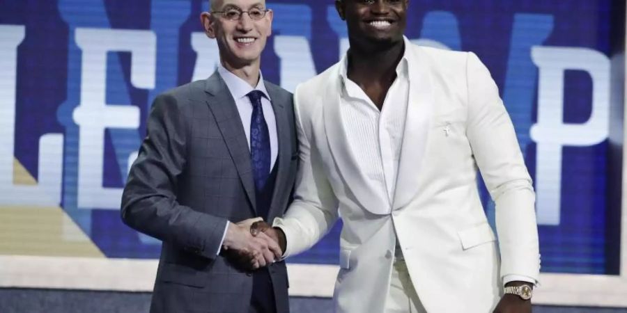 Zion Williamson (r) wird von NBA-Commissioner Adam Silver in der besten Basketballliga der Welt begrüsst. Foto: Julio Cortez/AP