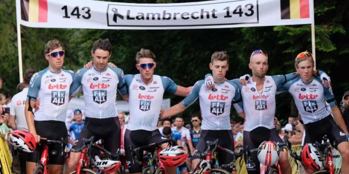 Die Fahrer des Teams Lotto Soudal stehen für eine Schweigeminute zum Tod von Bjorg Lambrecht mit Trauerflor vor einem Banner. Foto: Hanna Bardo/PAP l