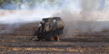 Strohballenpresse und Feld geraten in Brand.